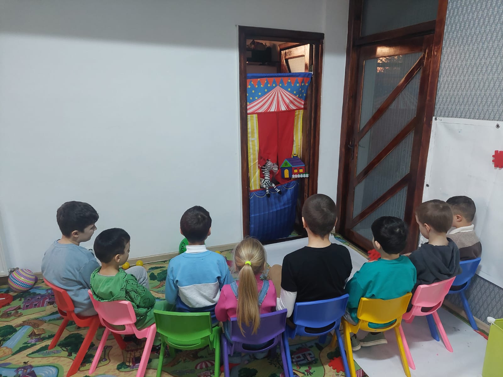 Copil pe traseu de echilibru în sală, alături de adult — exerciții psihomotorii
